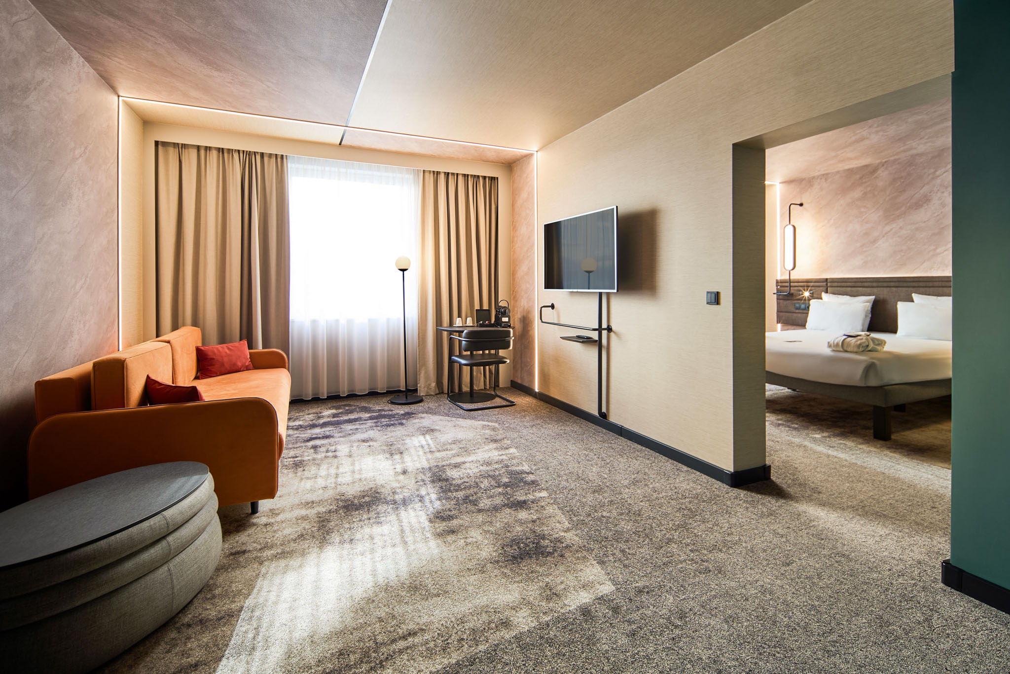 Wnętrze pokoju hotelowego Novotel w Pradze z częścią dzienną i sypialnianą
